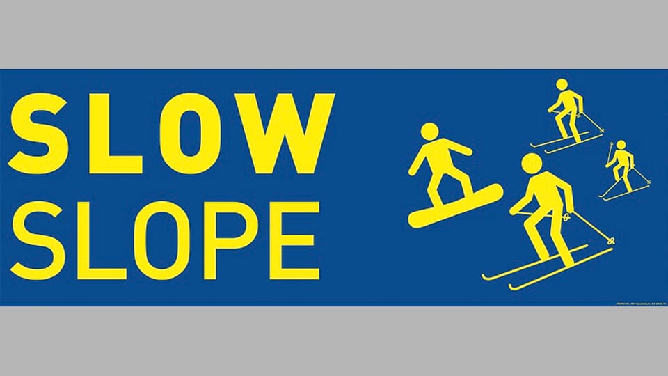 Schild mit Aufschirft Slow Slope und Piktorgrammen von Skifahrern.