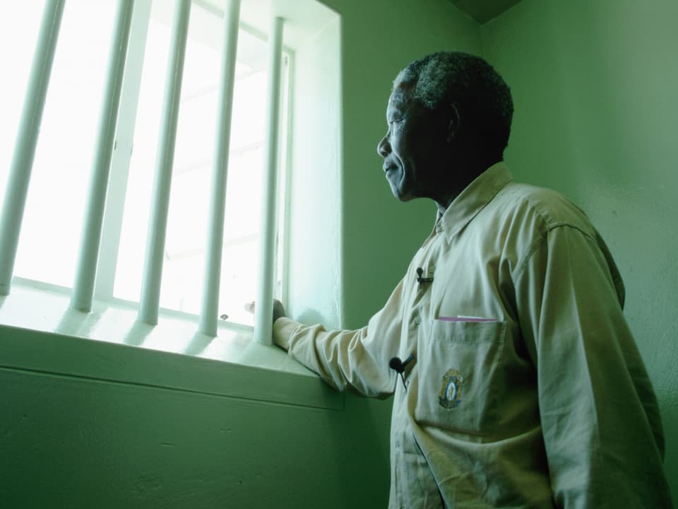 Nelson Mandela steht am Fenster seiner Gefängniszelle, in der er 27 Jahre lang gelebt hatte. Besuch auf Robben Island 1994.