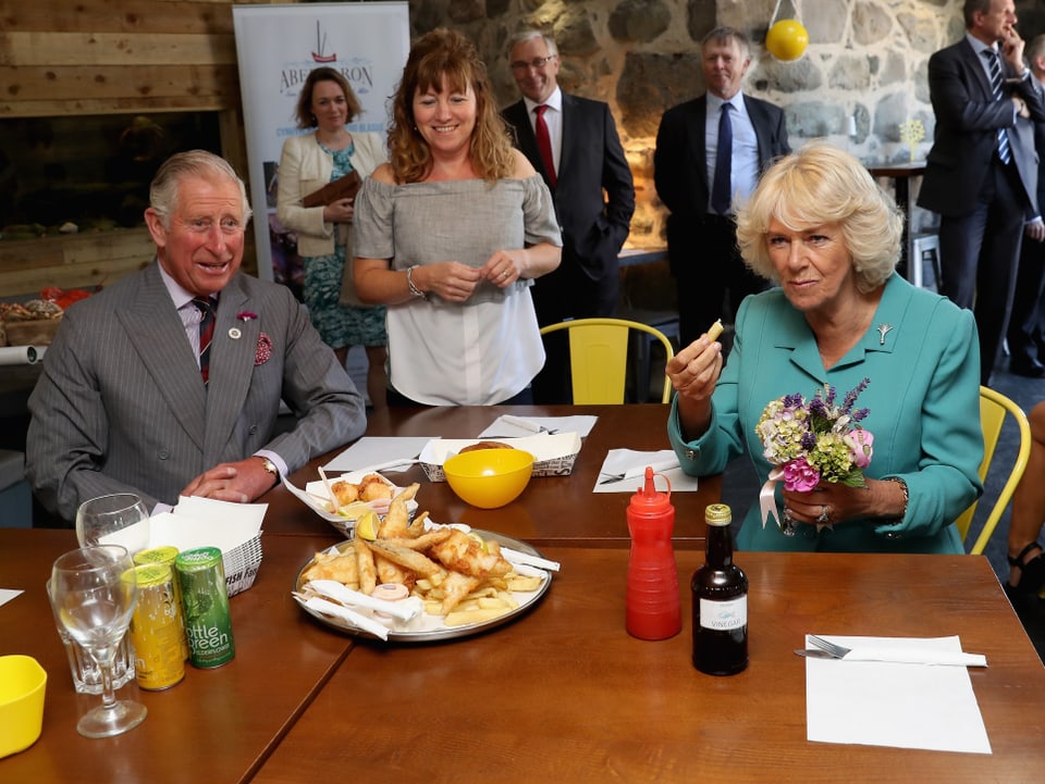 Während ihrem Besuch des walisischen Dorfes Aberdaron bekommen Charles und Camilla ganz traditionell Fish and Chips serviert. 