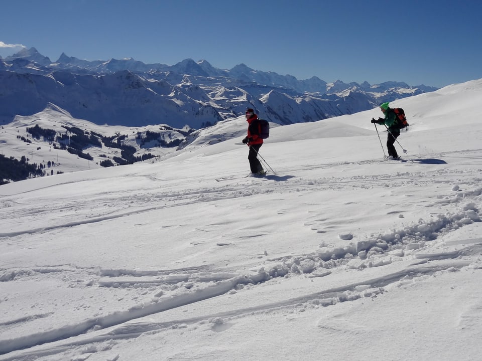 Zwei Skifahrer in den Berner Alpen, viel Sonne und blauer Himmel