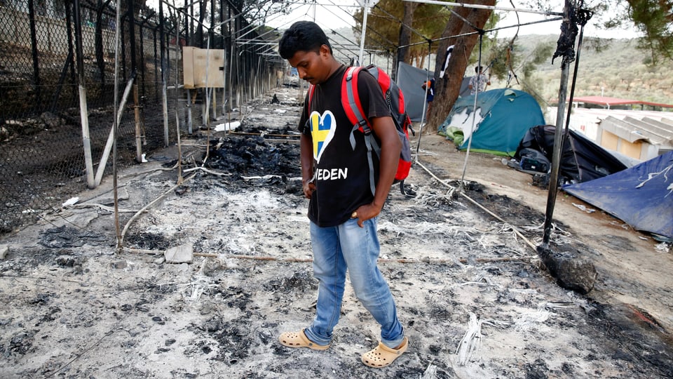 Ein Flüchtling steht alleine auf der niedergebrannten Fläche des Lagers in Moria.