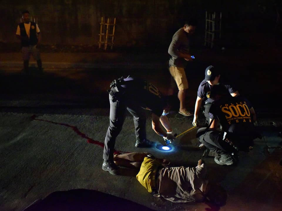 Zwei Polizisten beugen sich im Dunkeln über einen erschossenen mutmasslichen Drogendelinquenten.