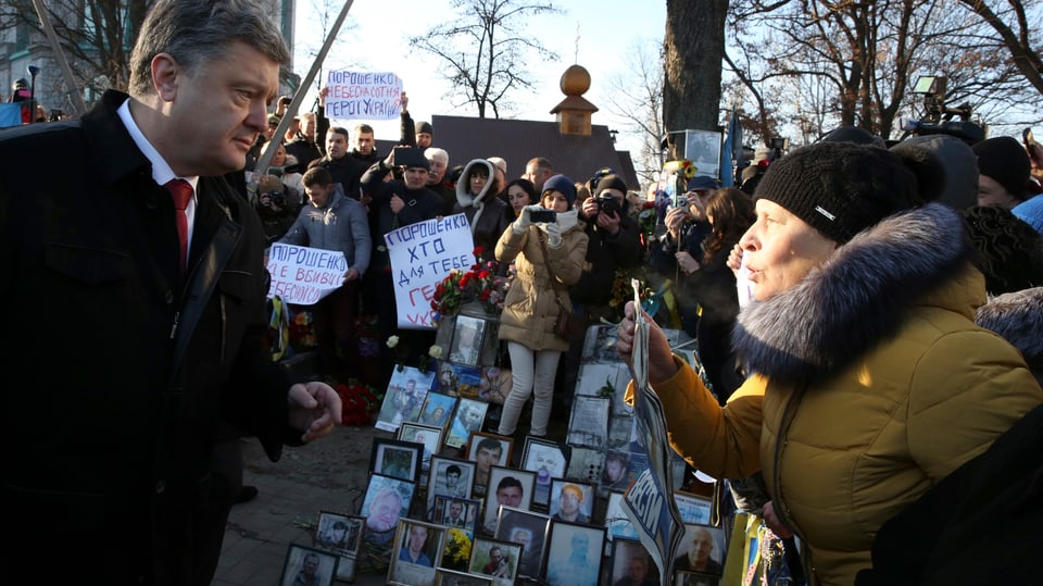 Präsident Poroschenko spricht an der Gedenkfeier mit einer protestierenden Frau