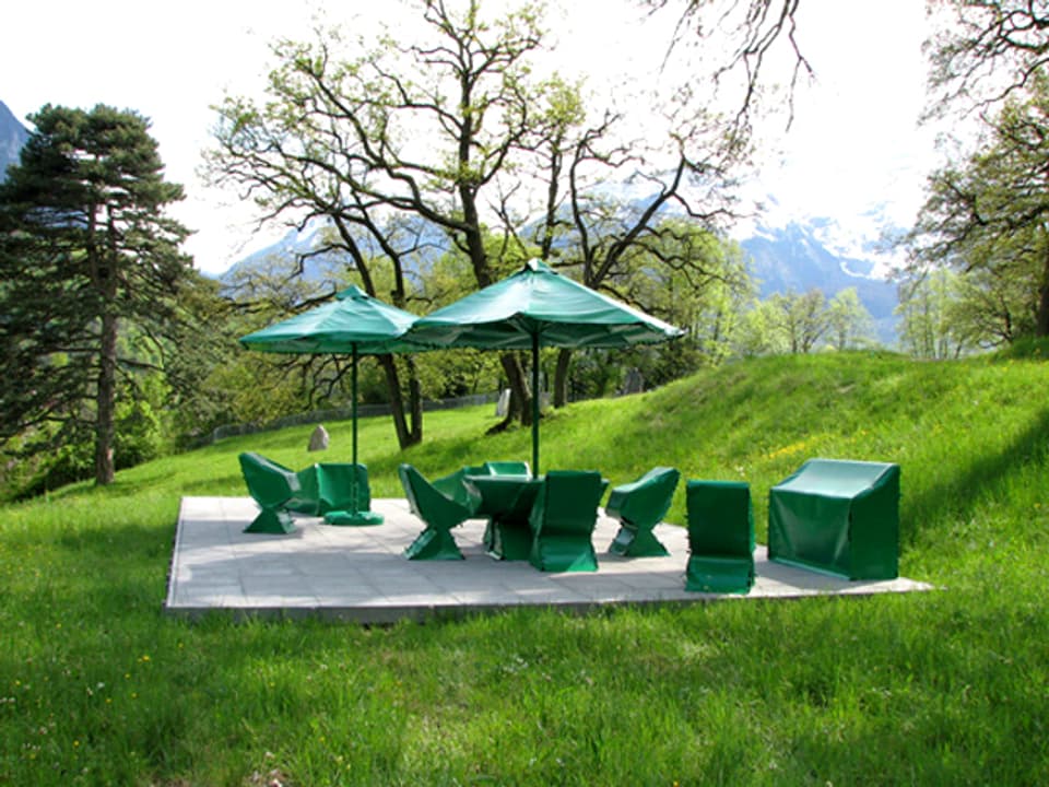 Die Installation «Eden» (2008) von Joëlle Flumet: zwei Sonnenschirme und Stühle mit grüner Schutzfolie abgedeckt