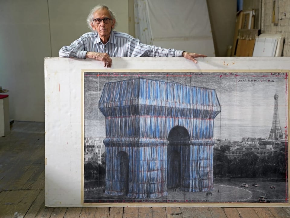 Künstler Christo steht vor einem riesigen Entwurf des in Stoff eingehüllten Arc de Triomphe