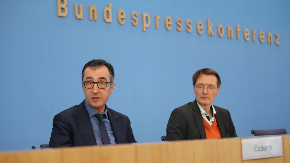 Cem Özdemir und Karl Lauterbrach sprechen von Podium an Pressekonferenz