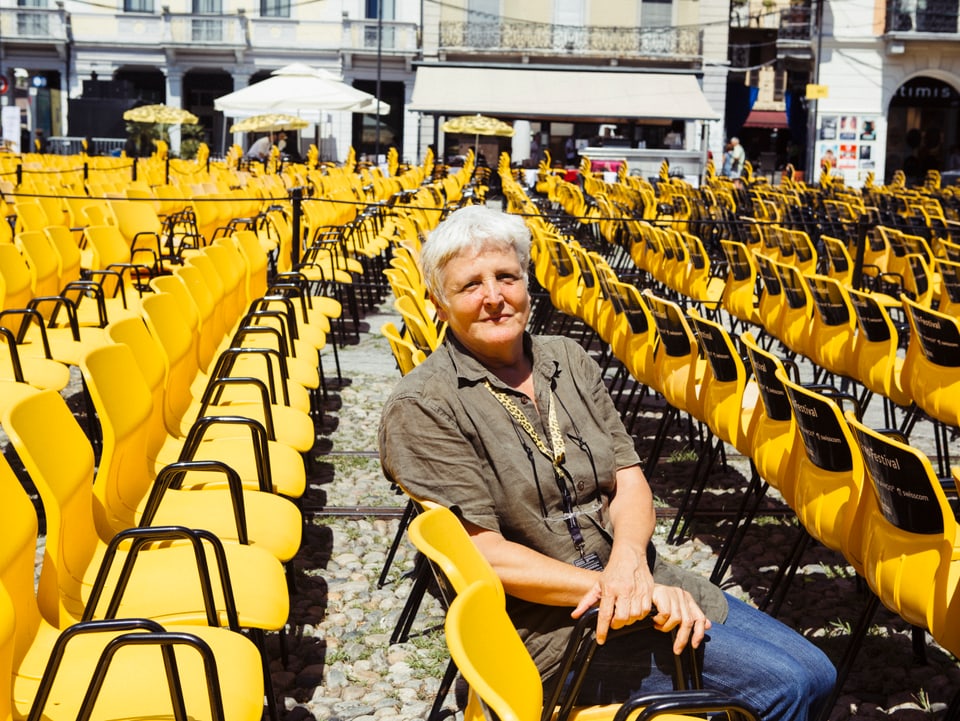 Frau mit Hemd auf gelben Stühlen