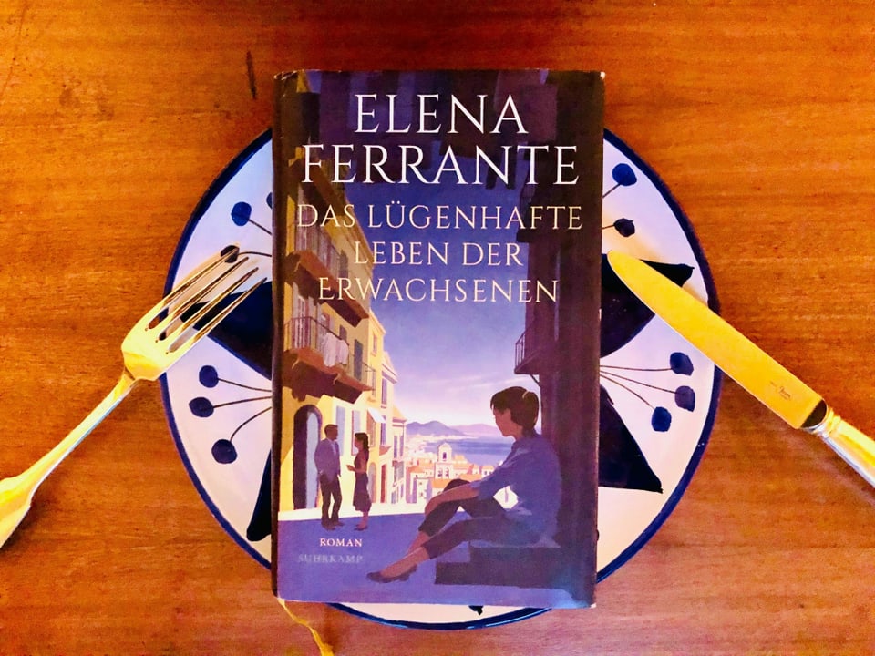 Der Roman «Das lügenhafte Leben der Erwachsenen» von Elena Ferrante liegt auf einem italienischen Keramik-Teller