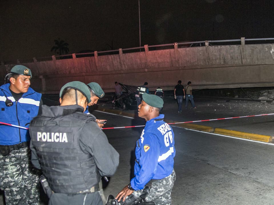  Rettungskräfte in Guayaquil neben einer zerstörten Brücke.