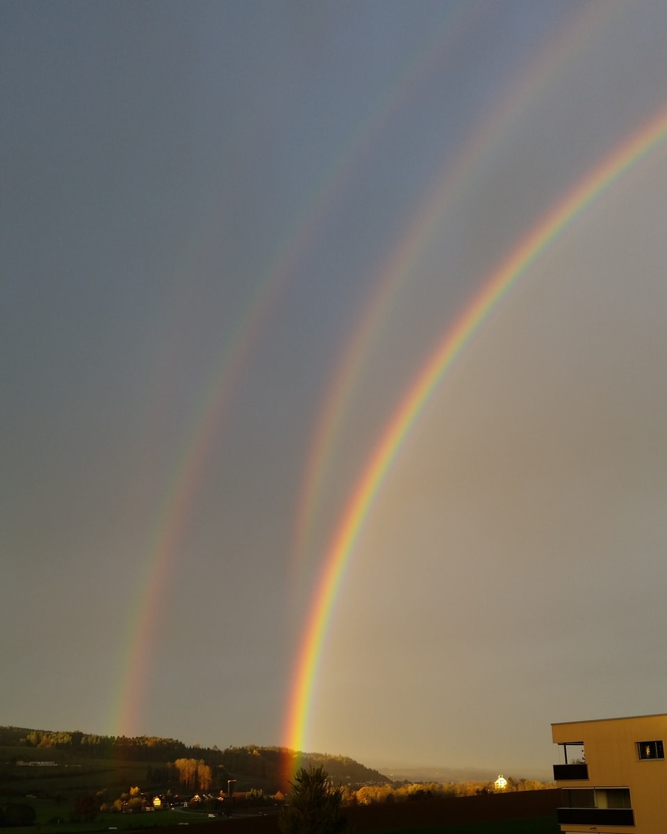 Ein doppelter Regenbogen und die Spiegelung dessen im Hintergrund.