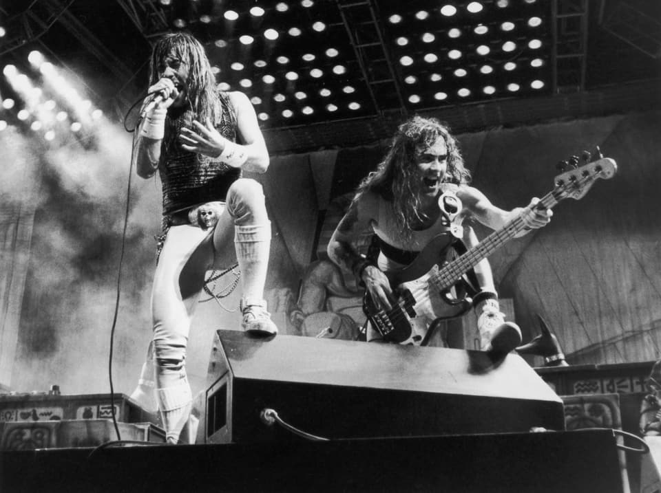 Heavy-Metal-Band Iron Maiden auf der Bühne, dem Publikum zugewendet. 