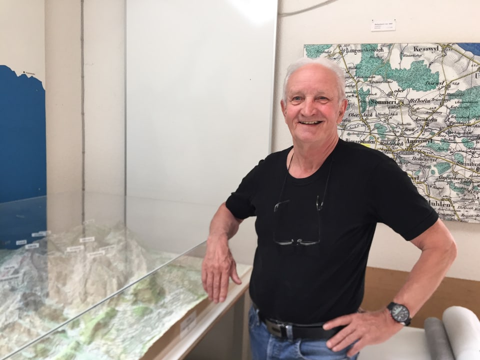 Ernst Schefer in seinem Atelier mit einem Relief hinter Plexiglas vom Alpsteingebiet.