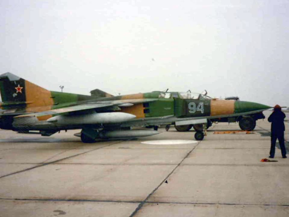 Kampfflugzeug mit Camouflage-Bemalung und rotem Stern am Heck auf Piste.