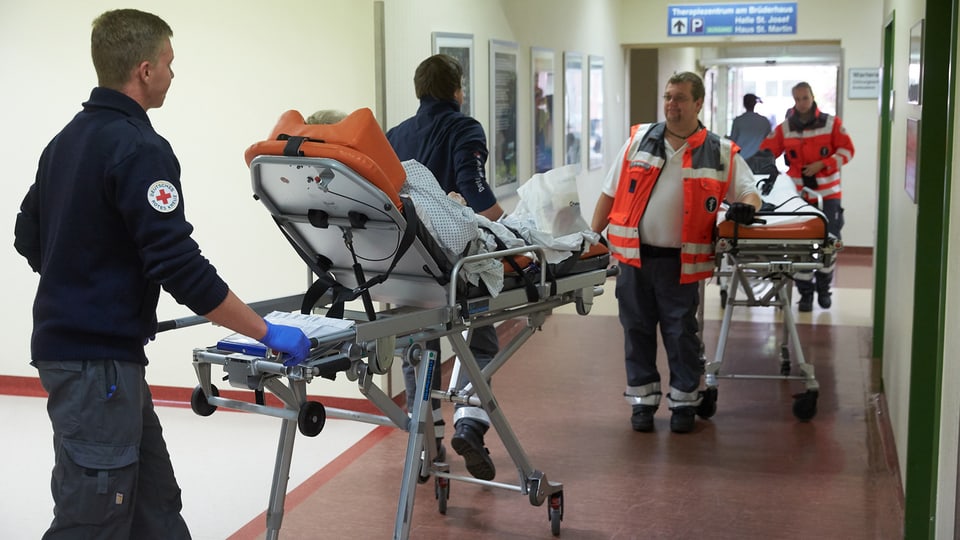 Mitarbeiter des Rettungsdienstes evakuieren Patienten aus einem Spital in Koblenz. 
