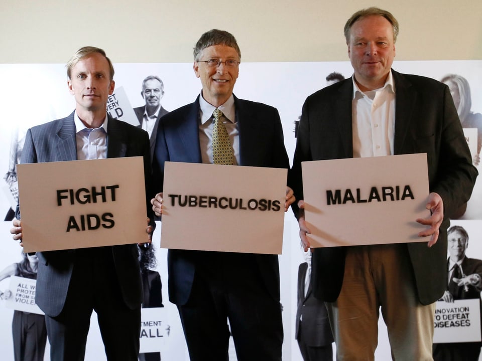 Mark Dybul, Bill Gates und Dirk Niebel halten Schilder mit den Worten «Fight Aids, Tuberkulose, Malaria» auf
