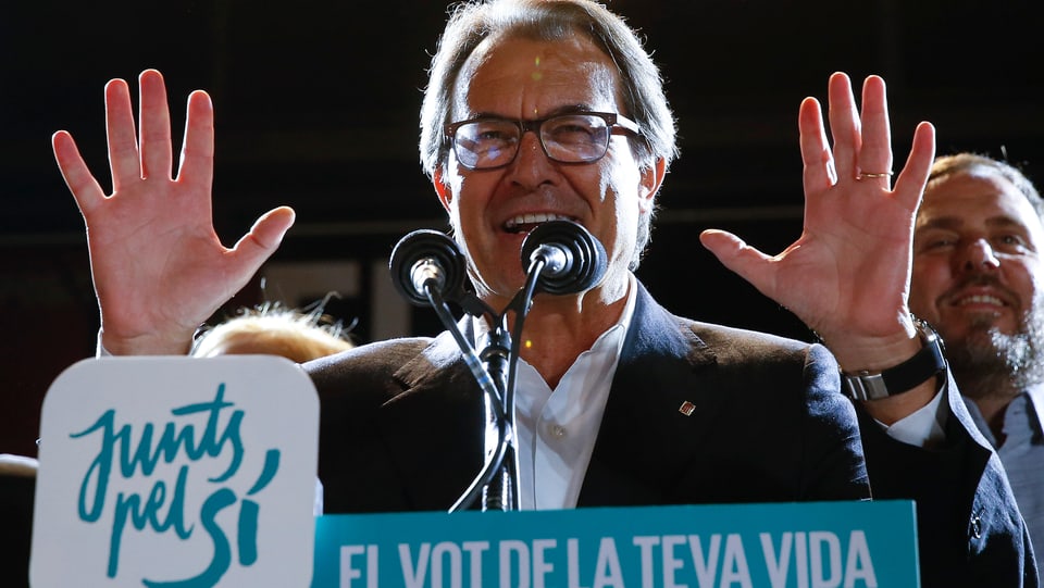 Der katalanische Regierungschef Artur Mas hebt die Hände und spricht in zwei Mikrofone.