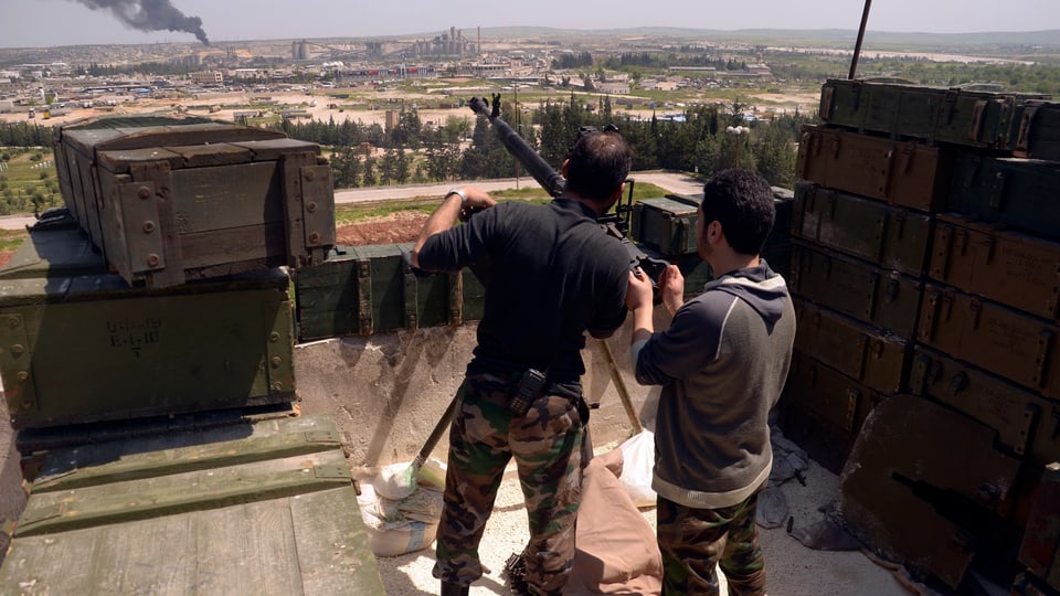 Zwei bewaffnete Männer auf einem Dach nahe Aleppo. 