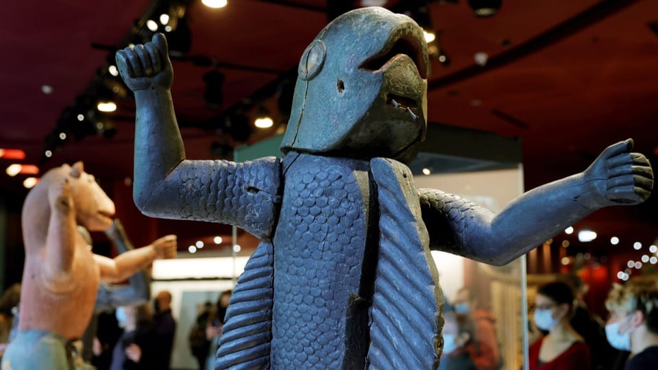Holz-Skulptur mit einem Fisch-Menschen in einem Museum.