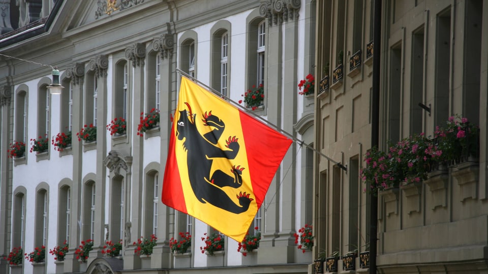 Eine Flagge mit dem Wappen von Bern hängt an schräg an einem Stab an einem Gebäude