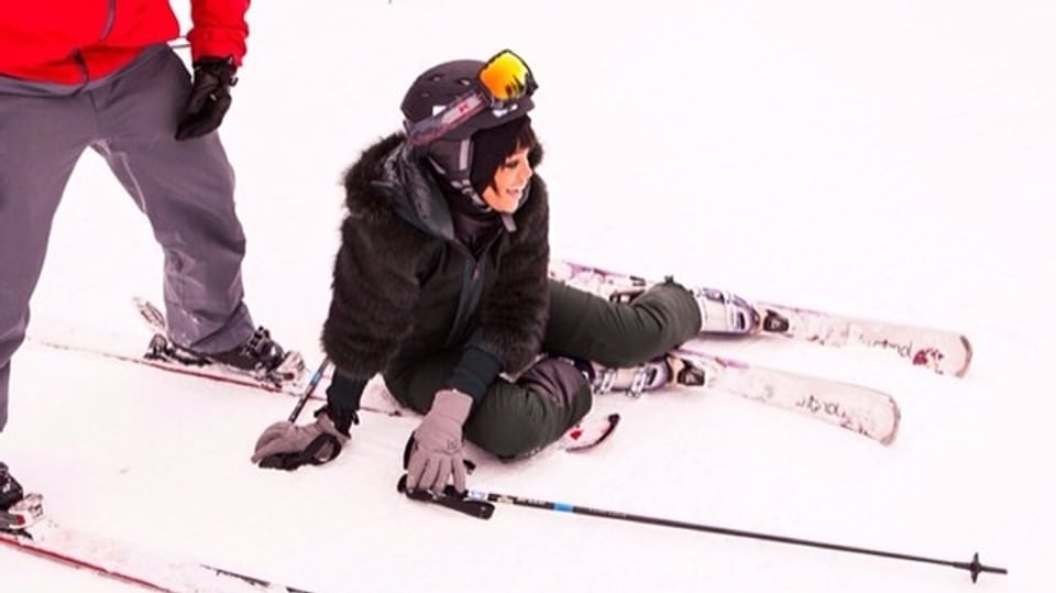 Sängerin Rihanna liegt mit Skiern am Boden.