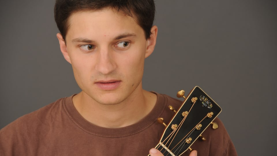 Der tschechische Liedermacher Jan Repka hät seine Gitarre im Arm.