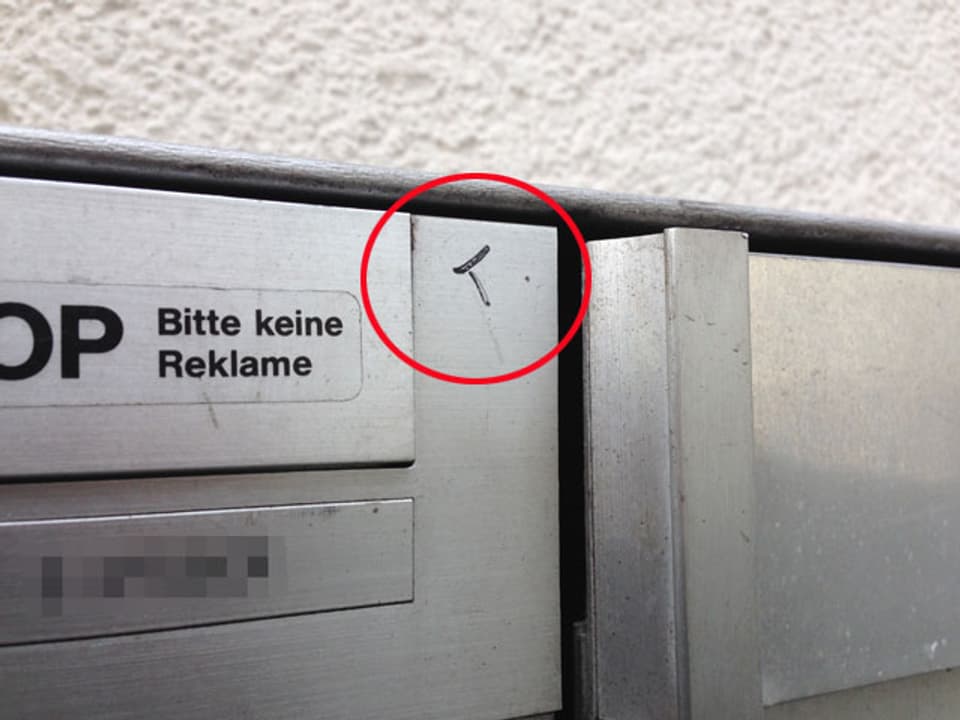 Auf einem Briefkasten wurde mit Filzstift ein T angebracht.