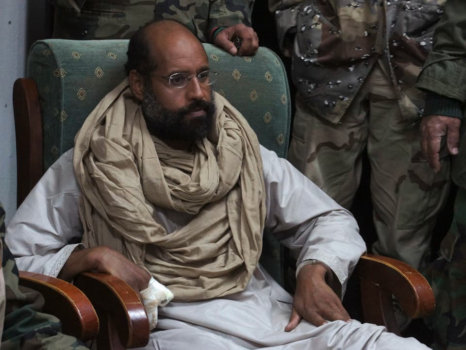 Saif al-Islam Gaddafi mit Bart umringt von Kämpfern.