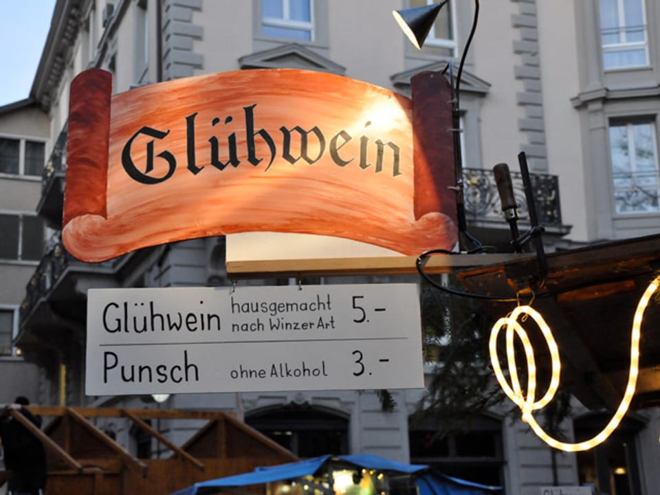 Marktstand mit einem Grossen Schild, auf dem Glühwein steht