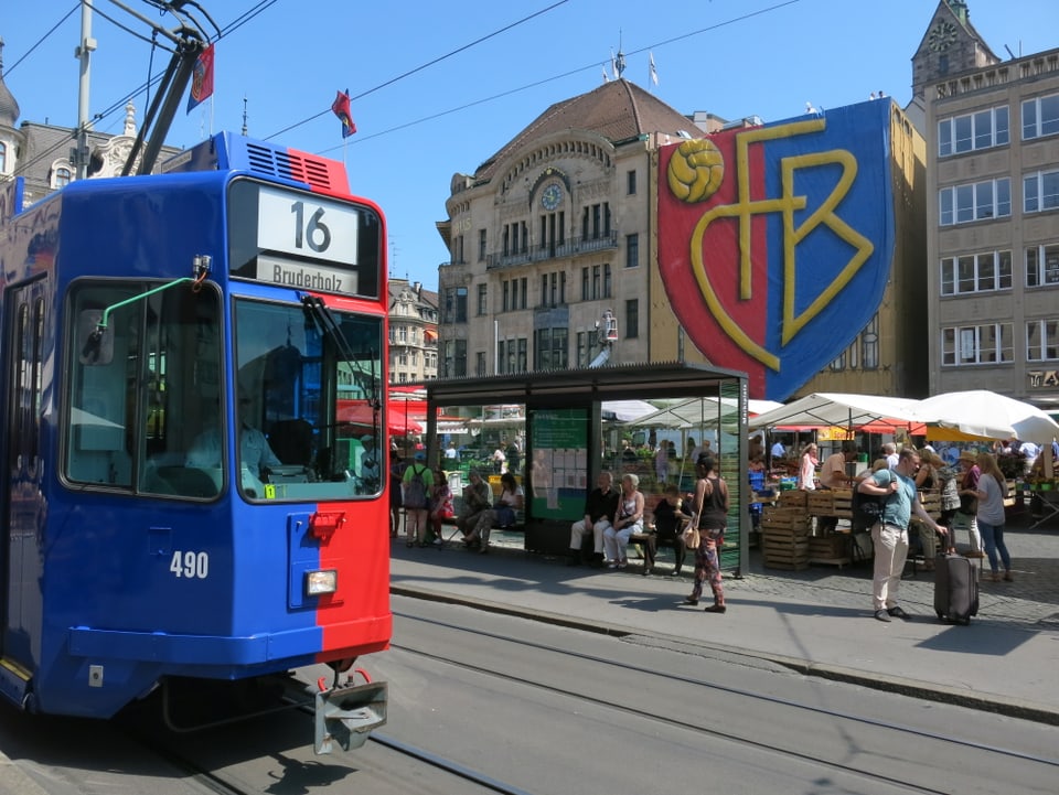 Ein Tram in FCB-Farben, im Hintergrund die Fassade des Globus mit rieser FCB-Flagge. 