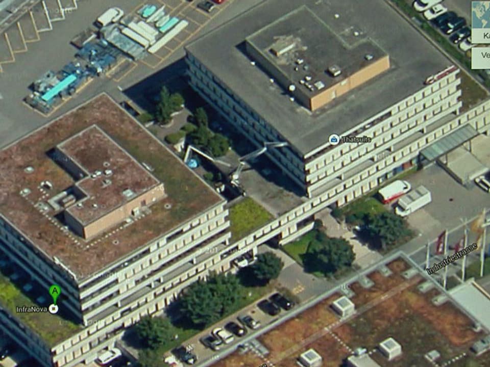 Vogelperspektive eines Gebäudes mit Parkplatz.