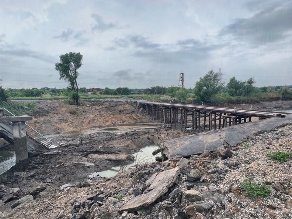 Ausgetrockenetes Flussbett mit zerstörtem Zement und Brückenteilen