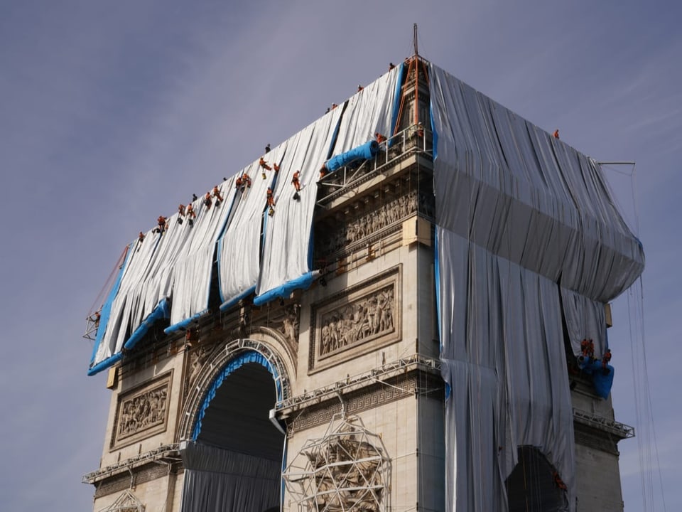 Stoff-Bahnen werden über den Arc de Triomphe in Parise gezogen