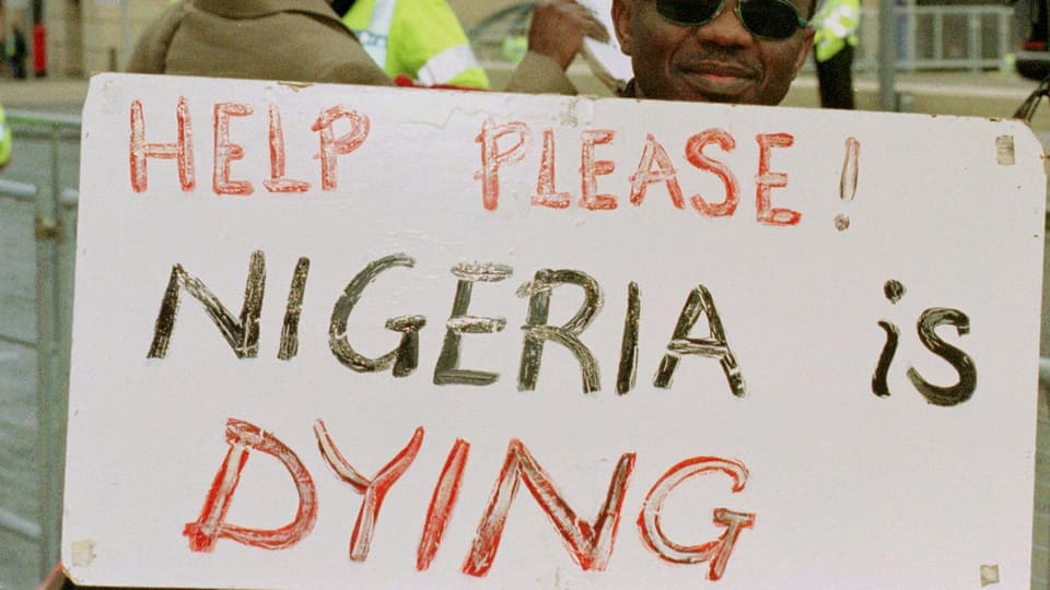 Ein Mann hält ein Transparent mit der Aufschrift «Help please, Nigeria ist dying»