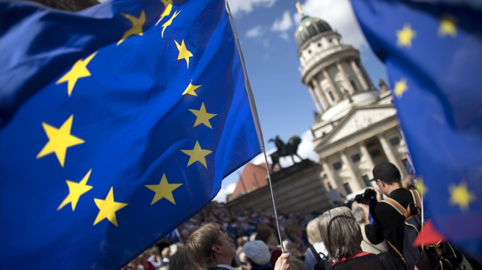 Symbolbild: EU-Flaggen und Menschen, aufgenommen auf dem Berliner Gendarmenmarkt.