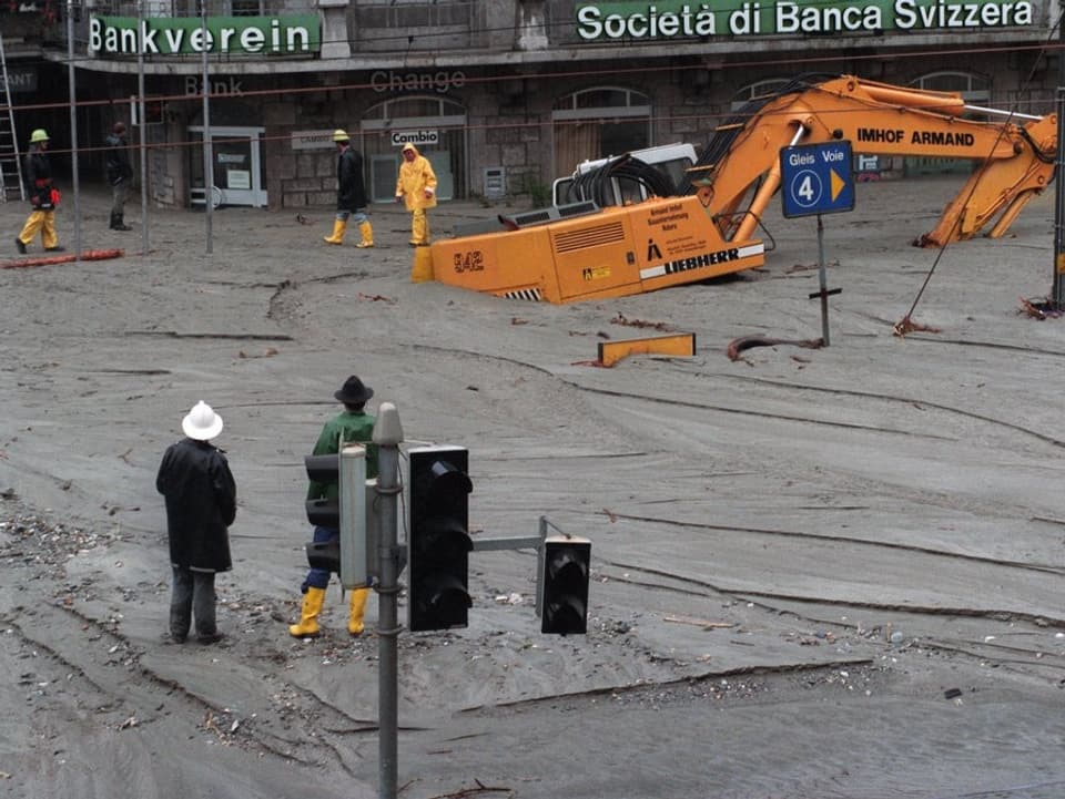 Schlamm liegt bis im ersten Stock der Gebäude. Ein Bagger blieb im Schlamm stecken.