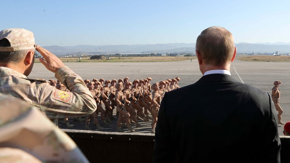 Putin nimmt auf einem flugfeld ein Defilee von Soldaten ab.