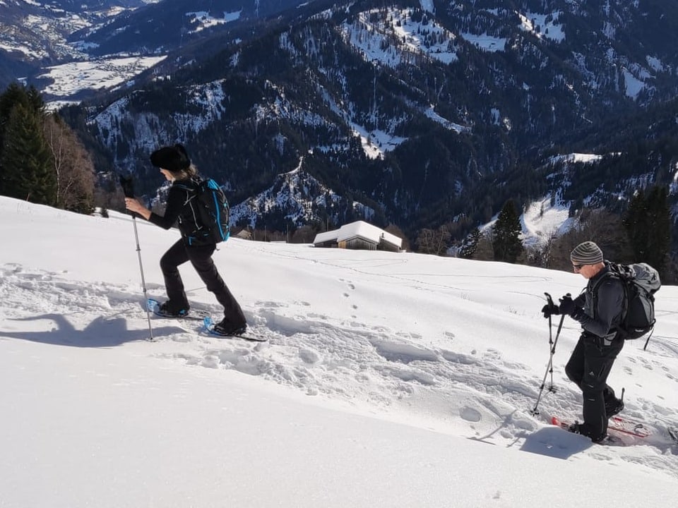 Zwei Schneeschuhläufer am Berg bei schönem Wetter.