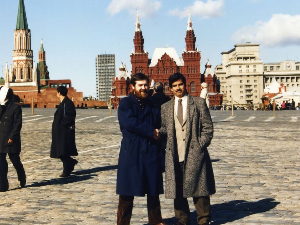 Zwei Männer stehen vor dem Kreml in Moskau und schütteln sich die Hand.