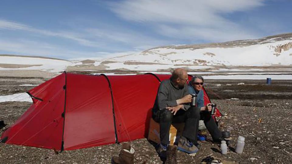 Björn Klauer und Regina Elpers sitzen vor einem roten Zelt.
