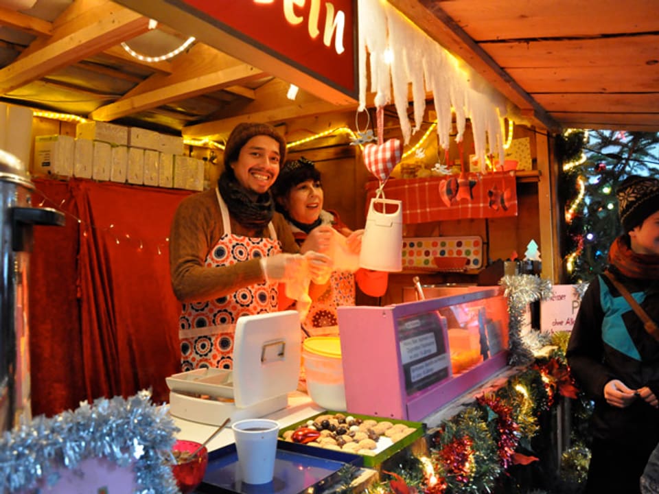 Ein Mann und eine Frau bieten an einem Stand Esswaren an