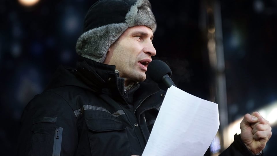 Klitschko mit Fellmütze und einem Manuskript bei seiner Rede.