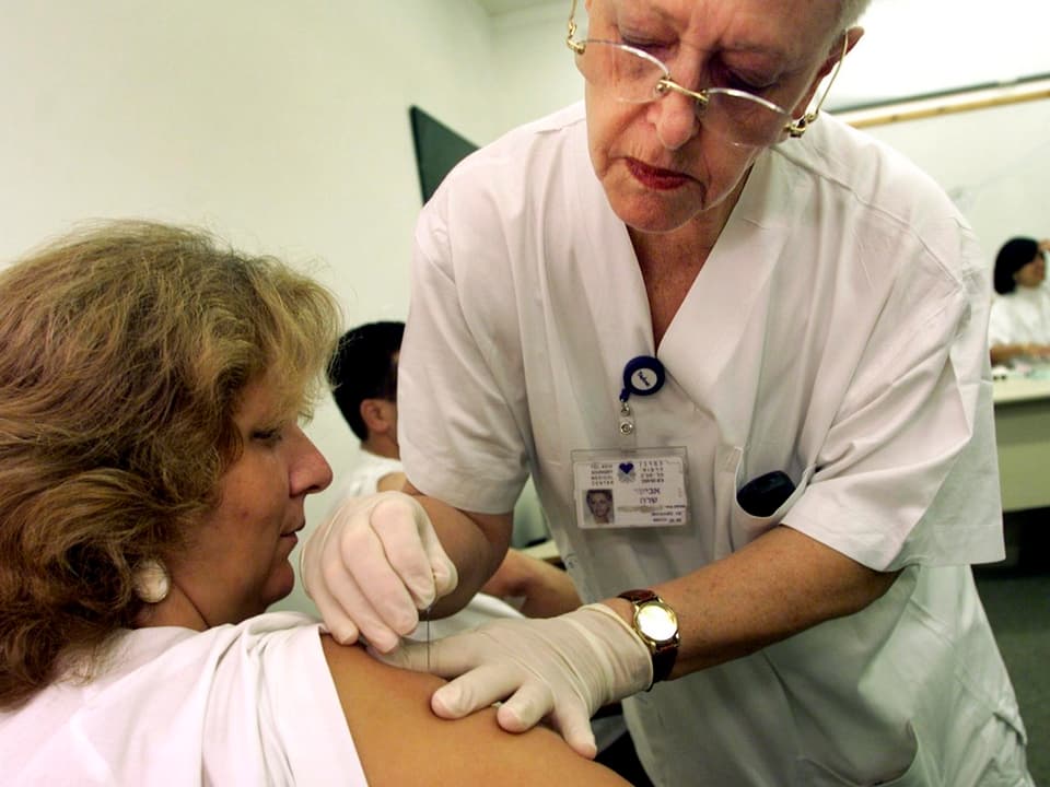 Ein Frau wird in einer Klinik in Tel Aviv in Israel am Oberarm gegen die Pocken geimpft.