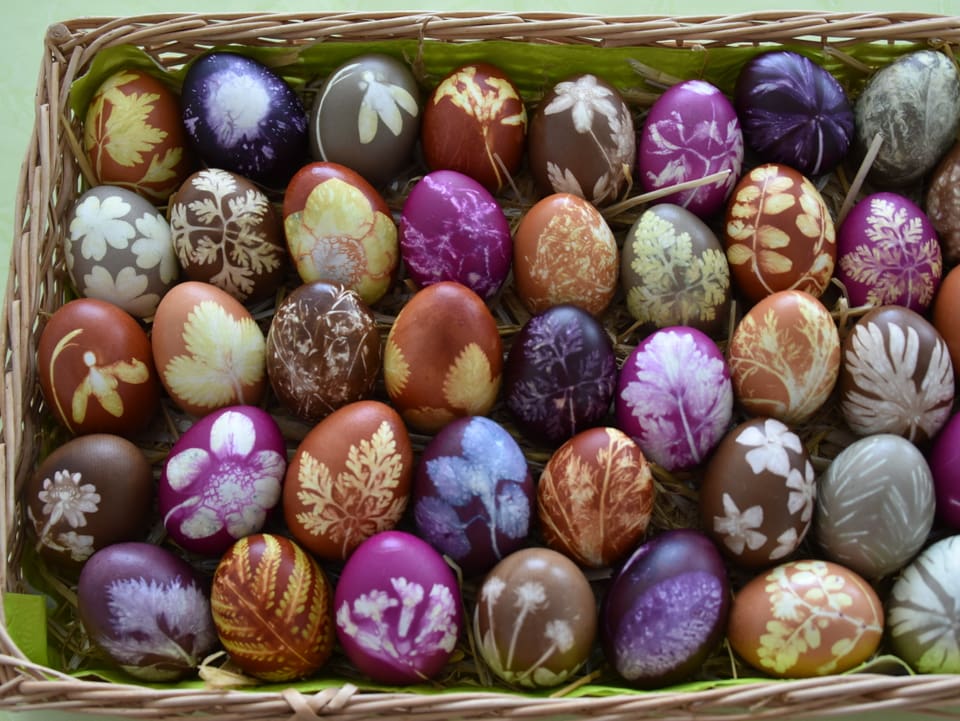 Viele Eier in vielen Farben und Mustern in einem Korb. 