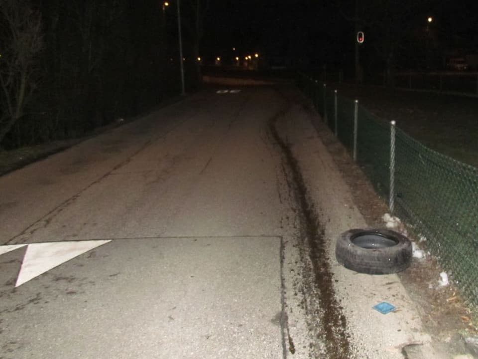 Die Ölspur führt weiter, am Strassenrand liegt der verlorene Reifen.