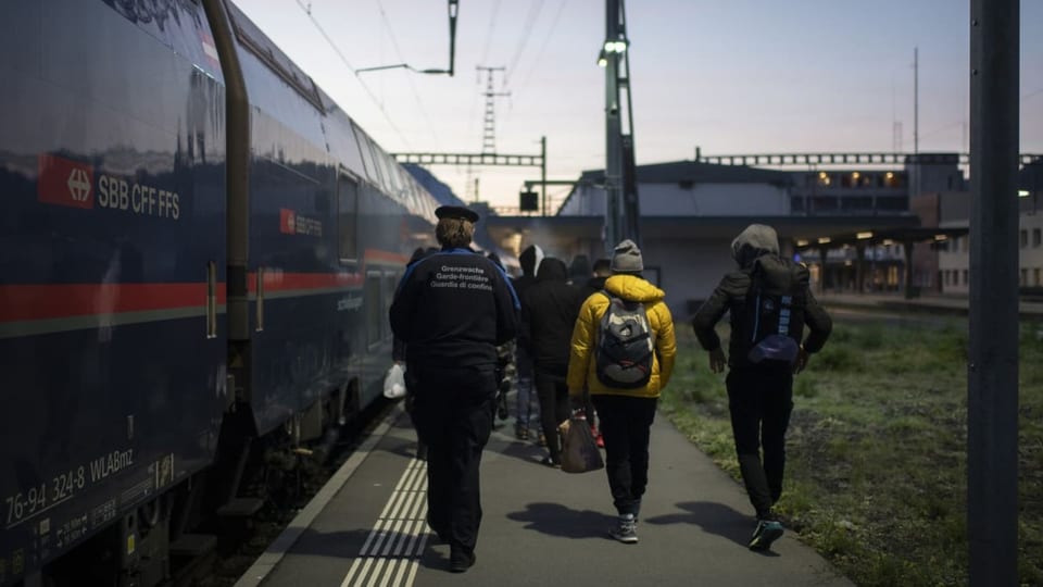 Grenzwächter bringen Flüchtlinge aus einem Zug aus Wien zur Kontrolle.