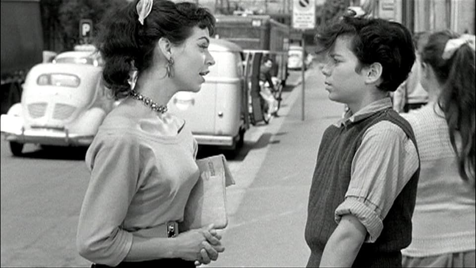Eine Frau spricht mit einem Jungen auf der Strasse.