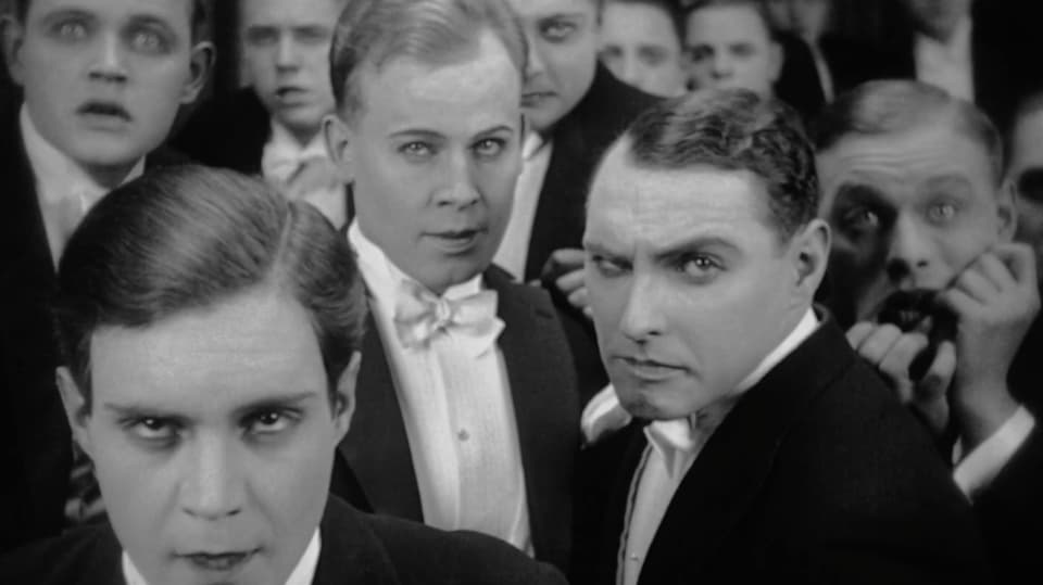 Eine Gruppe Männer schauen mit lüsternem Blick in die Kamera.