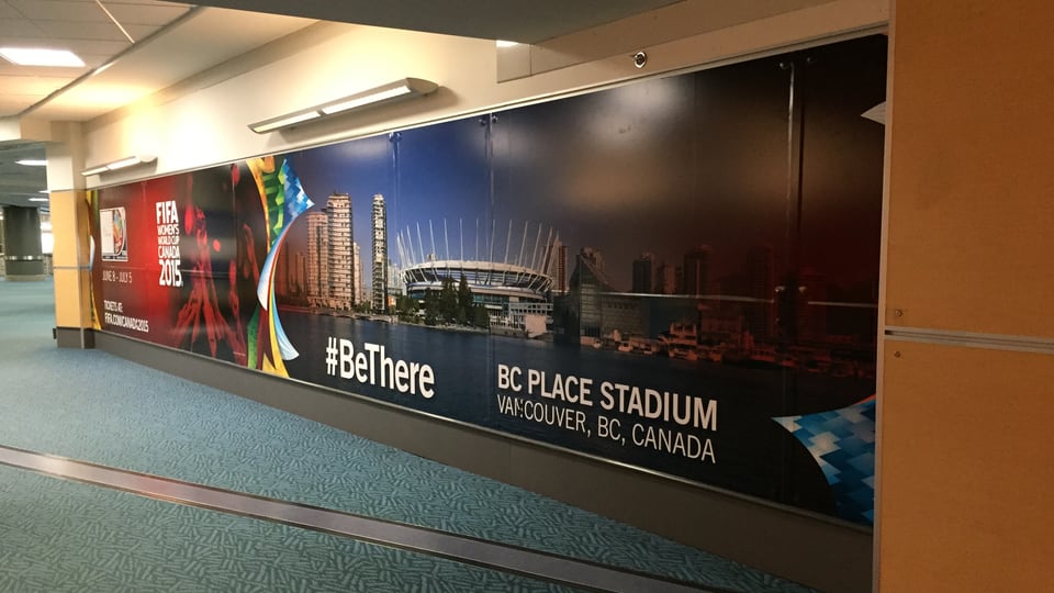WM-Plakat am Vancouver-Flughafen