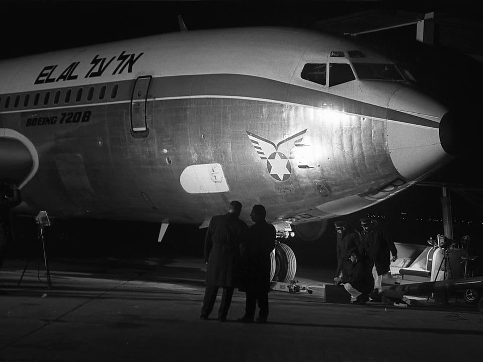 Fotografen machen Fotos eines stehenden Flugzeuges mit Einschusslöchern