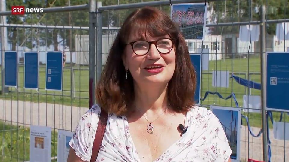 Heike Brüning gibt Interview vor dem Grenzzaun.